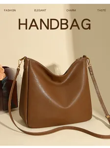 Detail view of the soft brown leather tote bag with metal zipper and embossed brand logo