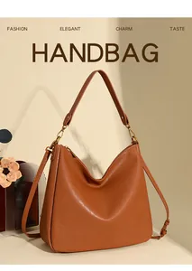 Detail view of the caramel brown leather hobo bag with gold hardware and wide shoulder strap