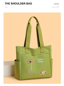 Dettaglio del ricamo floreale e del testo su una borsa tote in tela verde capiente