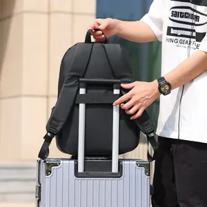 Sac à dos d'affaires noir avec sangle de bagage fixée sur une poignée de valise