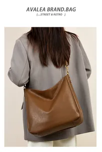Detail view of large brown soft leather hobo bag with vintage texture and gold hardware
