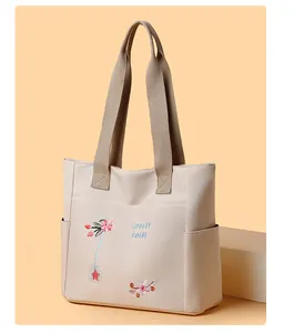Ricamo dettagliato di fiori e testo 'LOVELY FEIM' su una borsa tote in tela