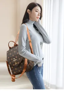 Detail of PVC backpack showing clover monogram print and gold kangaroo twist lock