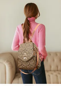 Brown printed diamond pattern backpack with golden kangaroo lock on a female model