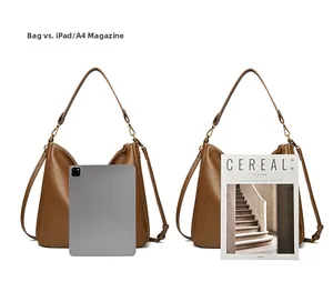 Brown leather hobo bag size comparison with an iPad and an A4 magazine on white background