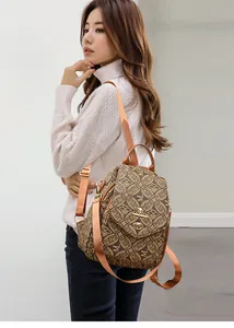 Detail view of brown vintage patterned backpack with metal kangaroo logo and turn-lock