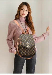 Detail view of the brown printed backpack featuring gold kangaroo hardware and leather texture