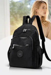Detail of black washed nylon backpack showing multi-pocket design and round logo patch