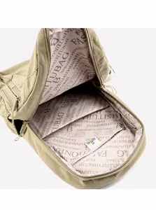 Detail view of khaki backpack interior with zipper compartment and letter printed lining