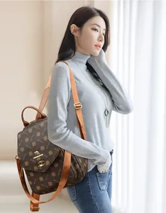 Detail of printed PVC backpack featuring a metal kangaroo logo and brand pattern