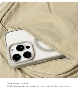 Detail showing an external zipper pocket of the khaki nylon backpack with a smartphone