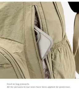 Macro detail of khaki nylon backpack featuring functional zipper pocket and side mesh pocket