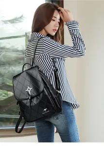 Close-up of black quilted leather backpack with sparkling star charm on the side pocket