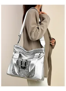 Detail der silbernen Ledertasche mit Schlangentasche und breitem Nylon-Schultergurt