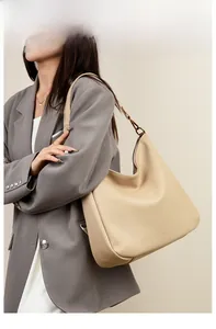 Model wearing a large beige soft leather hobo tote bag for commuting and fashion style