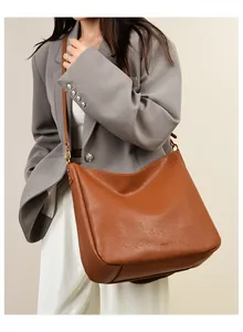 Macro detail of brown leather texture and adjustable strap on large hobo shoulder bag