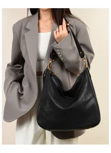 Model wearing a large black soft leather Hobo tote bag for stylish commuting fashion