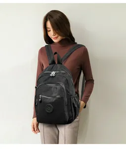 Détail d'un sac à dos noir en nylon avec poches zippées et patch logo circulaire