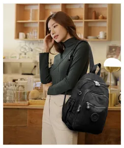 Détail d'un sac à dos en nylon noir avec compartiments zippés et poches latérales pratiques