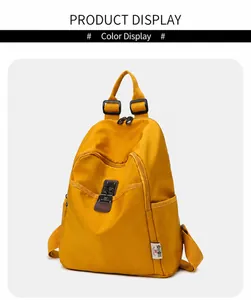 Detailed front view of a yellow waterproof nylon backpack with leather snap button accents
