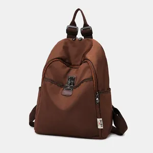 Front view of brown coffee nylon backpack with zipper pocket and metal brand plate