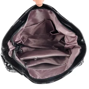 Geräumiges Innenleben der schwarzen Lederhandtasche mit Reißverschlussfächern und Satinfutter