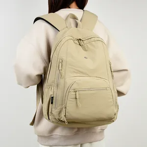 Minimalist khaki waterproof nylon backpack with textured fabric shown on a model