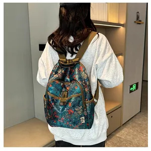 Detail of vintage floral backpack featuring brass buckle closures and dual front pockets