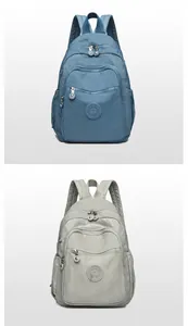 Detail view of water-resistant nylon backpacks in royal blue and light grey with logo