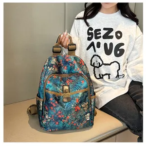 Detail of vintage floral backpack featuring bronze buckle and side pocket on blue canvas