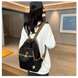 Detailed back view of the black printed fabric backpack with khaki straps on a model