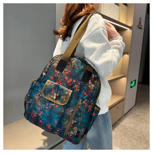 Detail of floral waterproof backpack with navy base and orange botanical prints