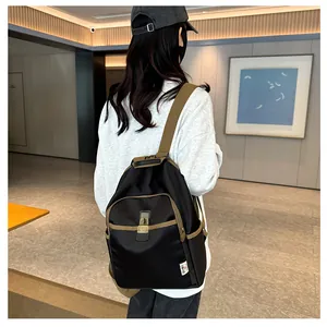 Detail of backpack with metal lock closure and contrasting brown straps on black fabric
