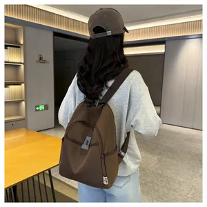Rear view of a casual brown nylon backpack with metal buckle and urban minimalist design