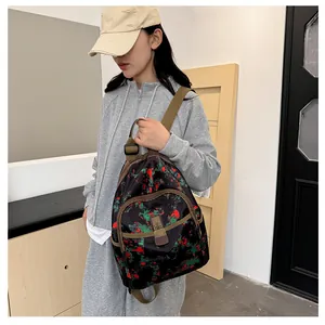 Detail of fabric backpack with floral print, front buckle pocket and brown straps