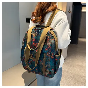 Detail of floral print backpack with khaki straps and vertical front zipper pocket