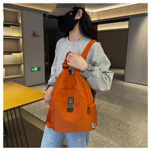 Detail view of a vibrant orange nylon backpack with side pockets and metal buckle