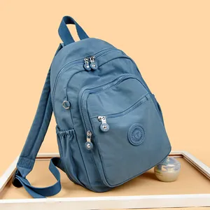 Sac à dos en nylon bleu Morandi avec multiples poches zippées et logo rond