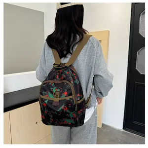 Detail of backpack with red and green abstract print, multi-pocket design and khaki straps