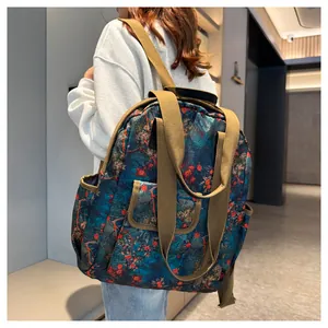 Rear view of a model wearing the floral print backpack with khaki woven straps and pockets