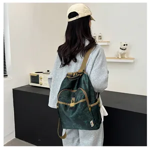 Detail of dark green backpack featuring bamboo patterns and durable khaki trim