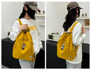 Detail of yellow nylon backpack featuring a secure metal twist lock and adjustable straps