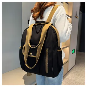 Close-up of black waterproof backpack with khaki straps on a model in a modern room