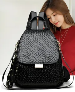 Detailed view of black woven faux leather backpack featuring gold studs and buckle closure