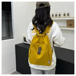 Detail view of yellow nylon backpack with adjustable straps and silver metal buckle