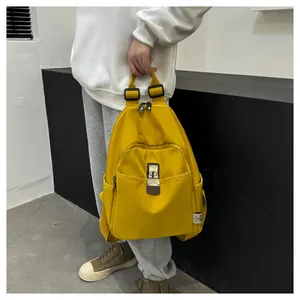 Detail of yellow nylon backpack featuring side pockets and metal magnetic clasp closure