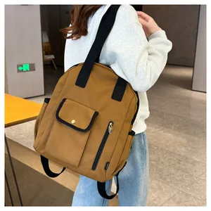 Detail of mustard yellow canvas backpack featuring front flap pocket and gold button closure