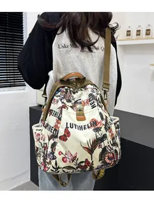 Détail du sac à dos blanc cassé avec imprimé floral, boucle antivol et sangle verte