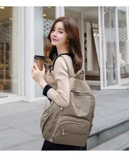 Détail d'un sac à dos en nylon kaki avec poches zippées et porte-bouteille latéral pratique