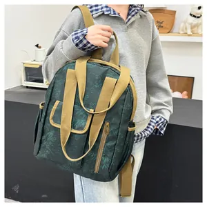 Detail of dark green floral backpack with khaki canvas straps and metal logo zippers
